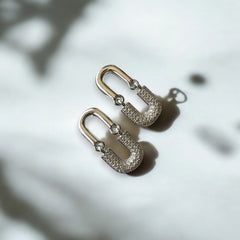 Aretes en forma de clip de acero plateado con circones blancos.