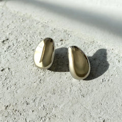 Aretes plateados de acero inoxidable con diseño minimalista y acabado pulido. Modernos y versátiles.