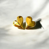Aretes corazón facetado de acero dorado en alto relieve.