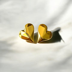Aretes corazón facetado de acero dorado en alto relieve.