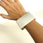 Brazalete de acero inoxidable mate con diseño geométrico minimalista. Sofisticado y moderno.