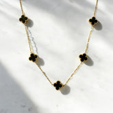 Collar de acero con tréboles negros esmaltados. Diseño elegante y sofisticado.