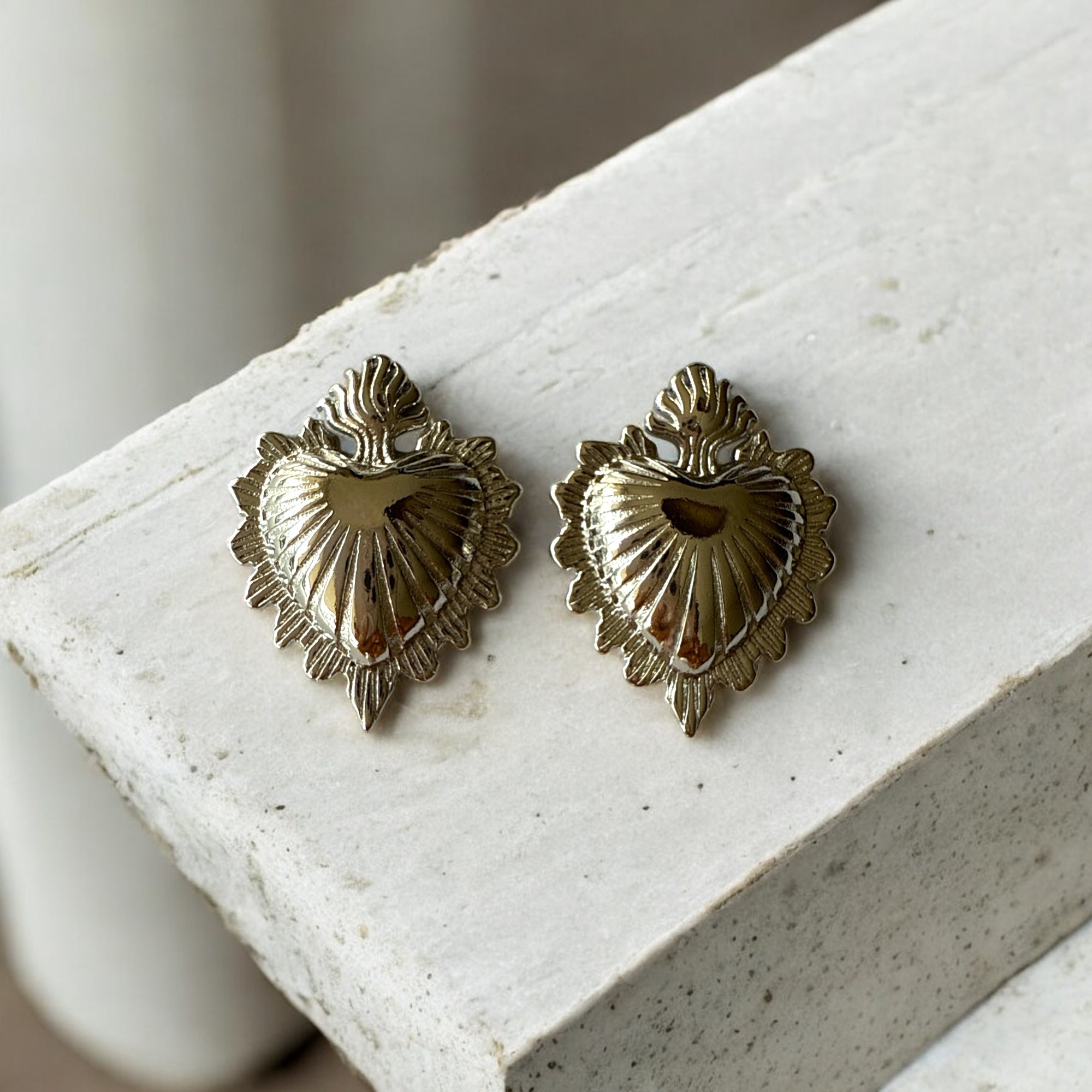 Aretes Corazón Exvoto de acero inoxidable plateado con diseño detallado en relieve.