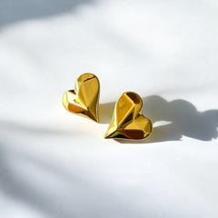 Aretes corazón facetado de acero dorado en alto relieve.