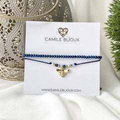 Pulsera de hilo ajustable azul doble con una linea de muranos y otra con dije de abeja con circones bañado en oro 18K