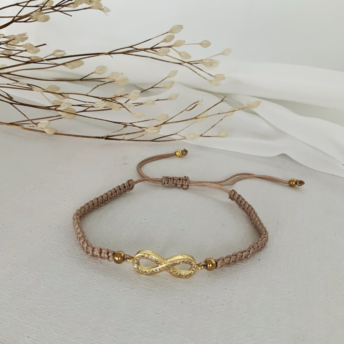 Pulsera de hilo ajustable nude con infinito dorado con circones