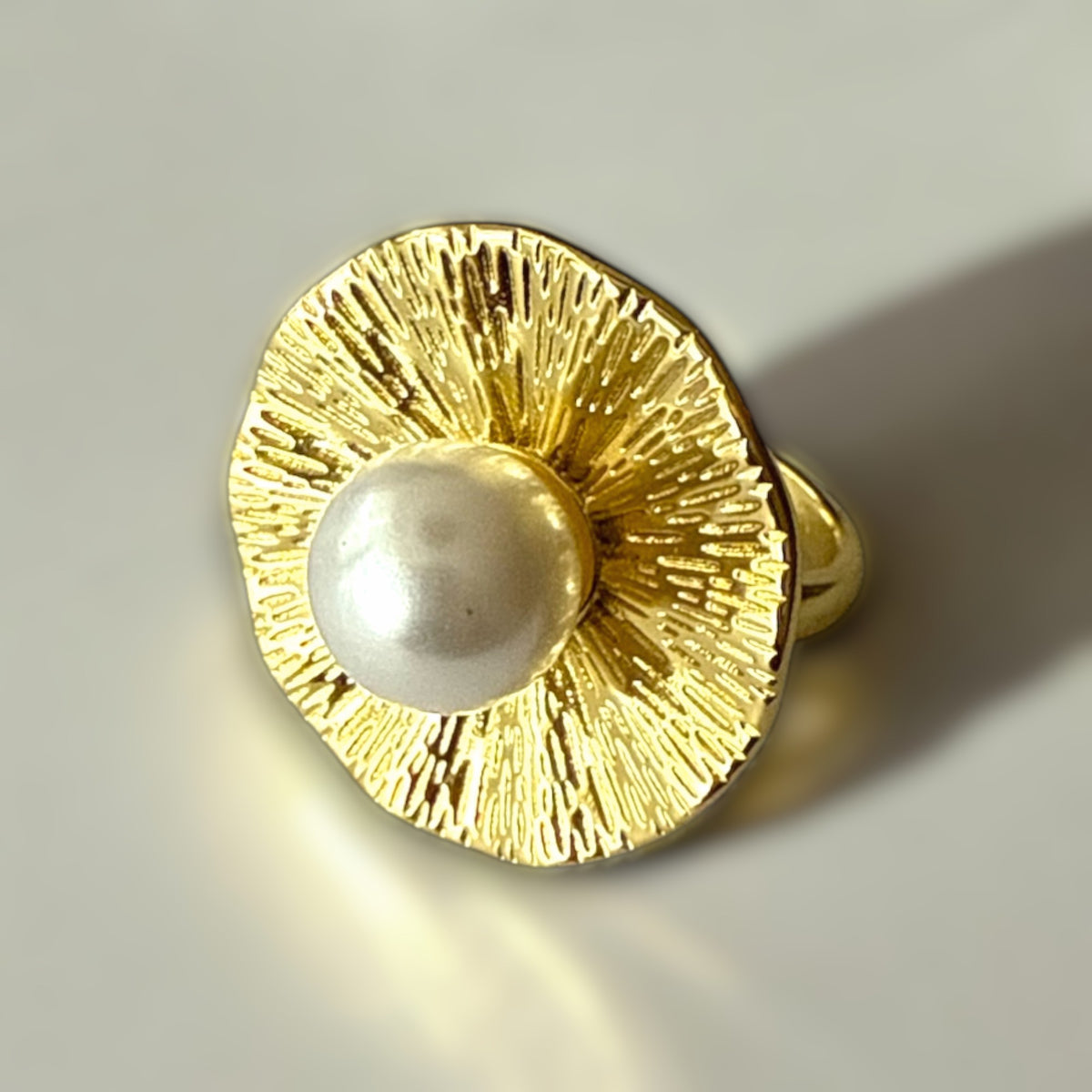 Anillo ajustable de acero dorado con perla y diseño floral