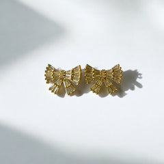 Aretes lazo dorado con circones blancos en acero bañado en oro, diseño femenino y sofisticado.