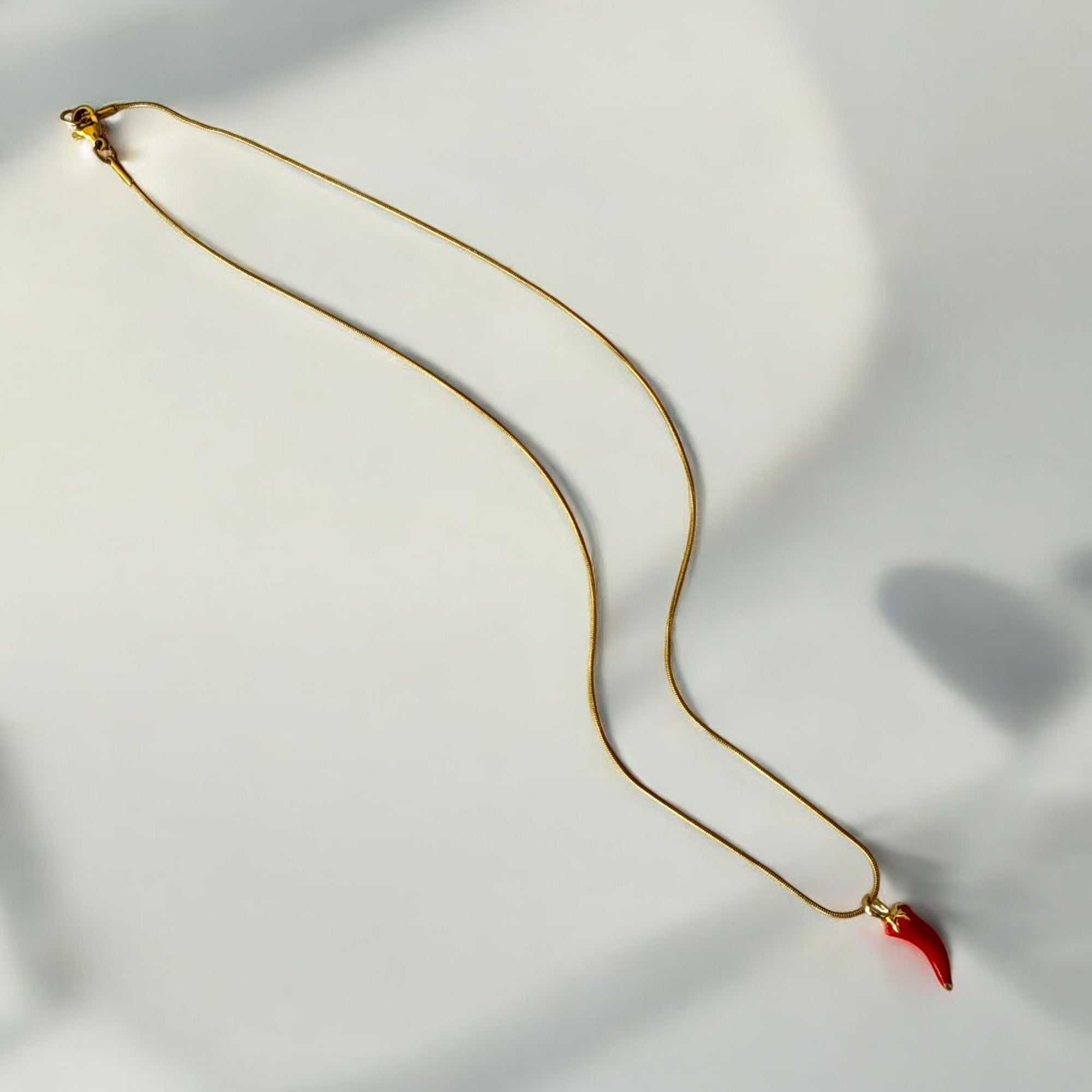 Collar de acero bañado en oro con dije de chilli rojo esmaltado y cadena Snake de 1 mm, 44 cm. Diseño vibrante y llamativo.