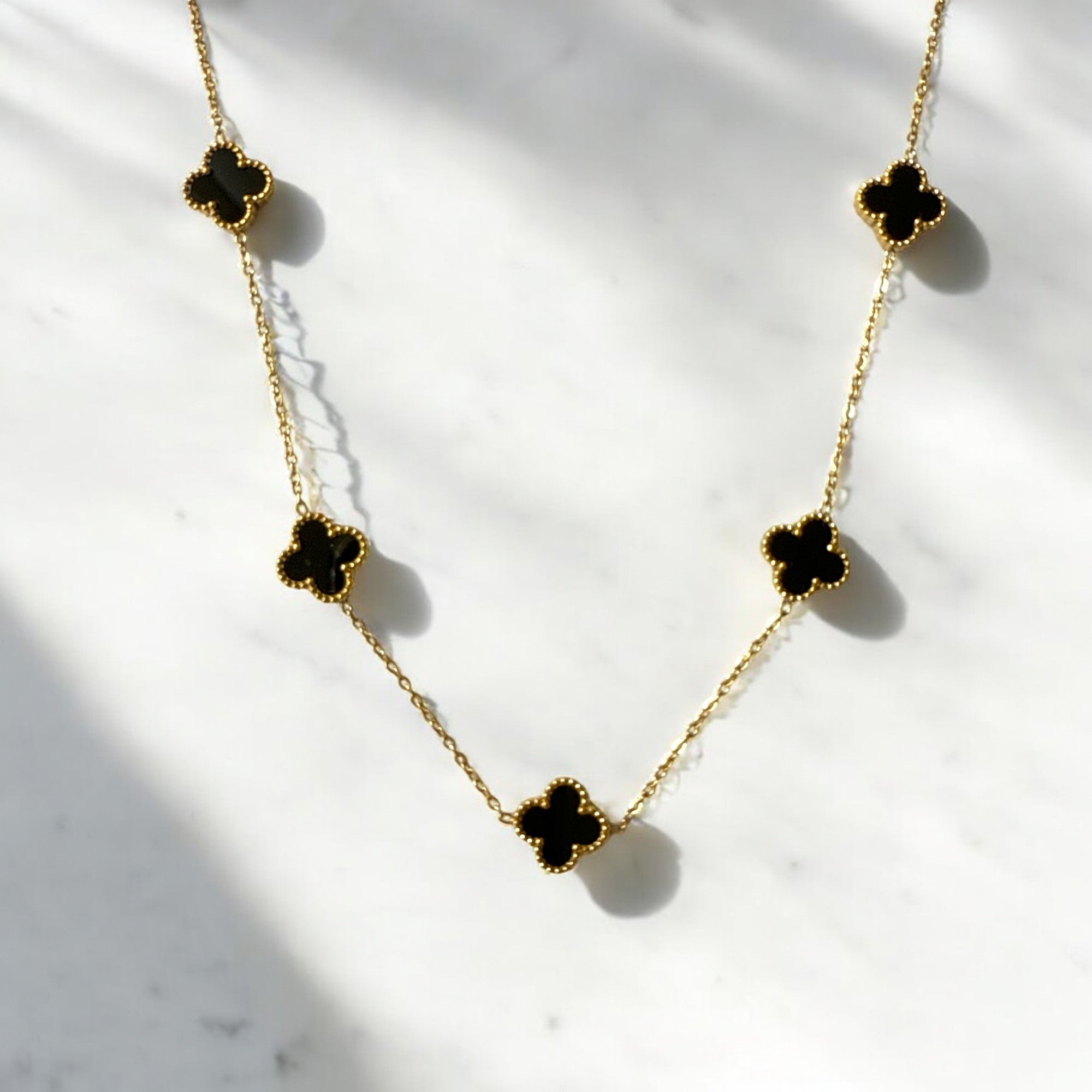 Collar de acero con tréboles negros esmaltados. Diseño elegante y sofisticado.