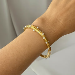 Pulsera ajustable CAMILE BIJOUX de acero dorado con perlas blancas y circonias brillantes en la muñeca