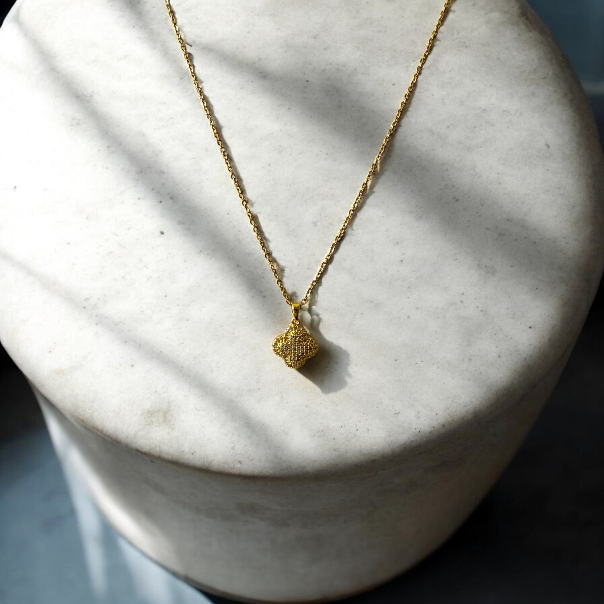 Collar de acero bañado en oro con dije de trébol y circones brillantes. Diseño sofisticado y elegante.