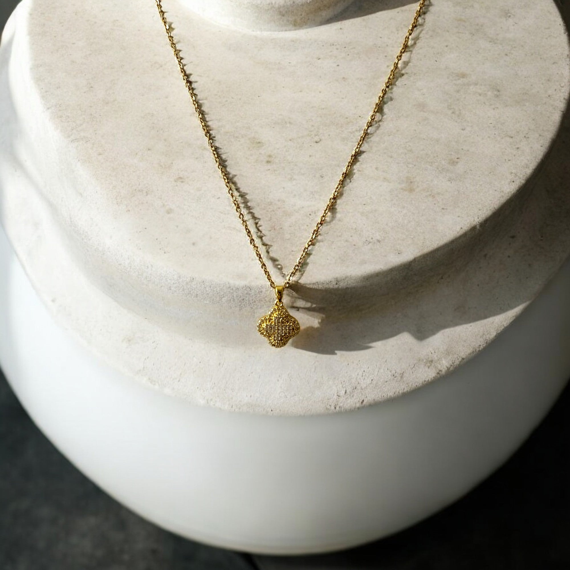 Collar de acero bañado en oro con dije de trébol y circones brillantes. Diseño sofisticado y elegante.