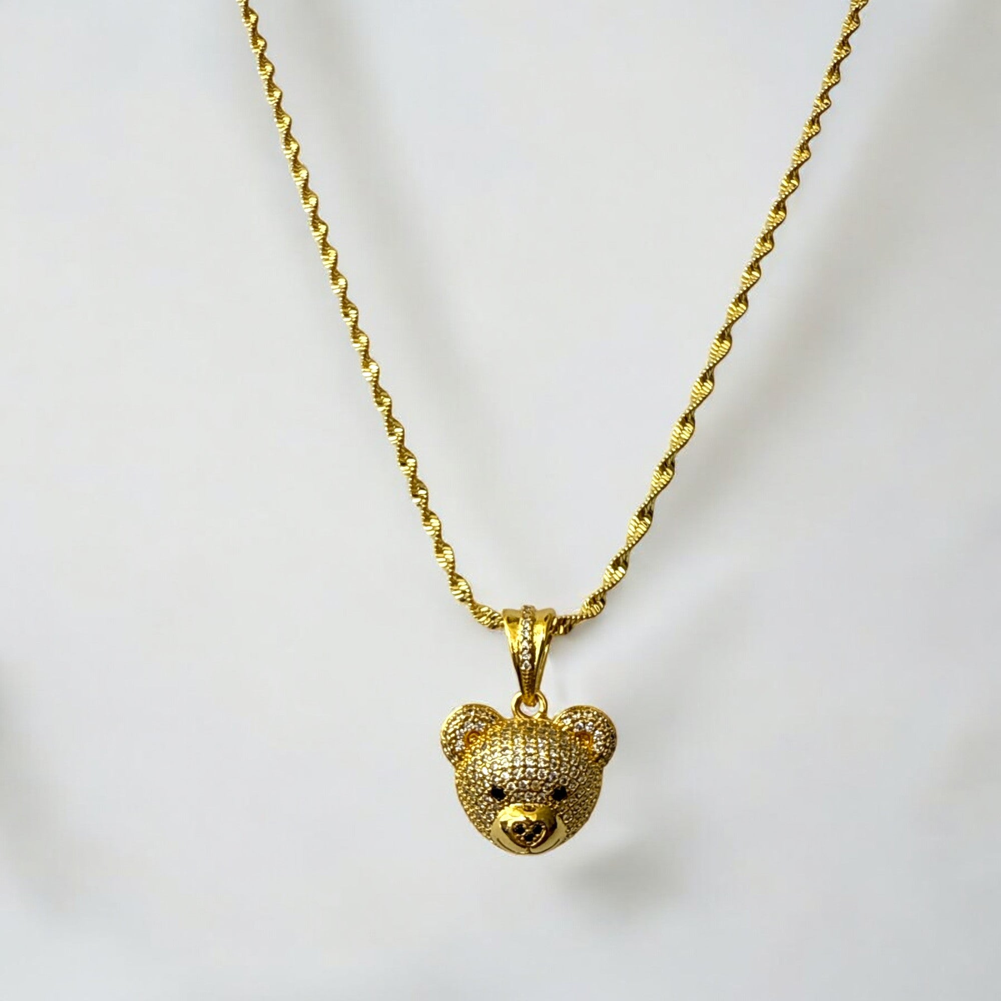 Collar de acero bañado en oro con dije de oso incrustado con circones y cadena rope de 2 mm. Diseño llamativo y elegante.