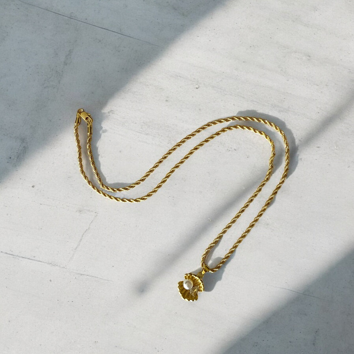 Collar de Acero Bañado en Oro con Concha y Perla