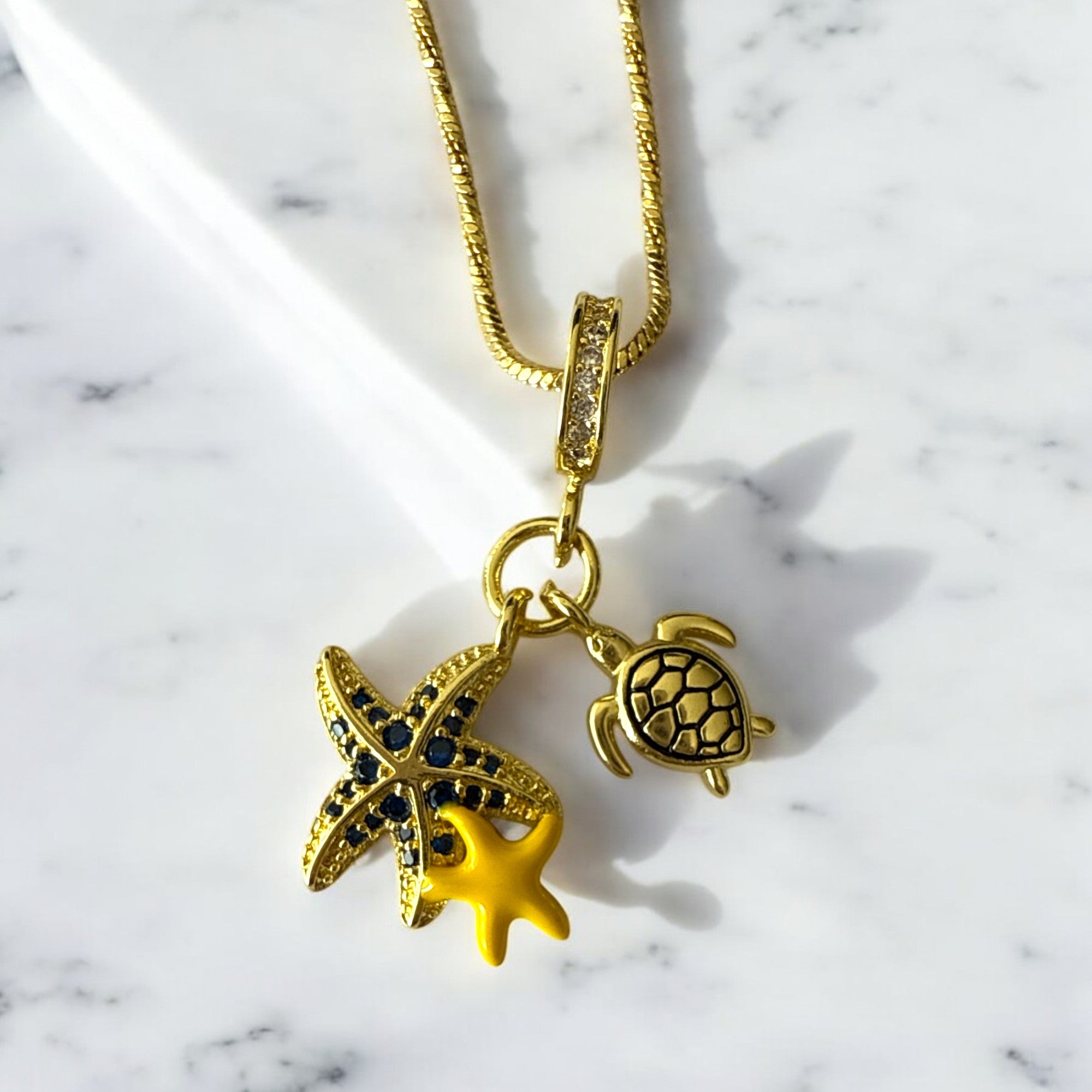 Collar de acero bañado en oro con dijes marinos esmaltados y cadena fina de 1 mm, 44 cm abierta. Diseño fresco y elegante.